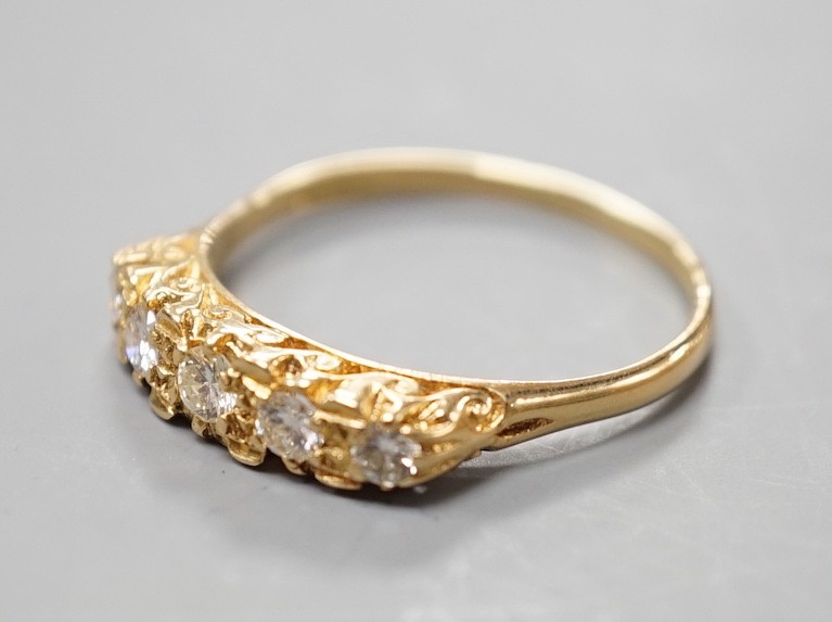 A modern 18ct gold and graduated five stone diamond set half hoop ring, size T, gross weight 3.8 grams.